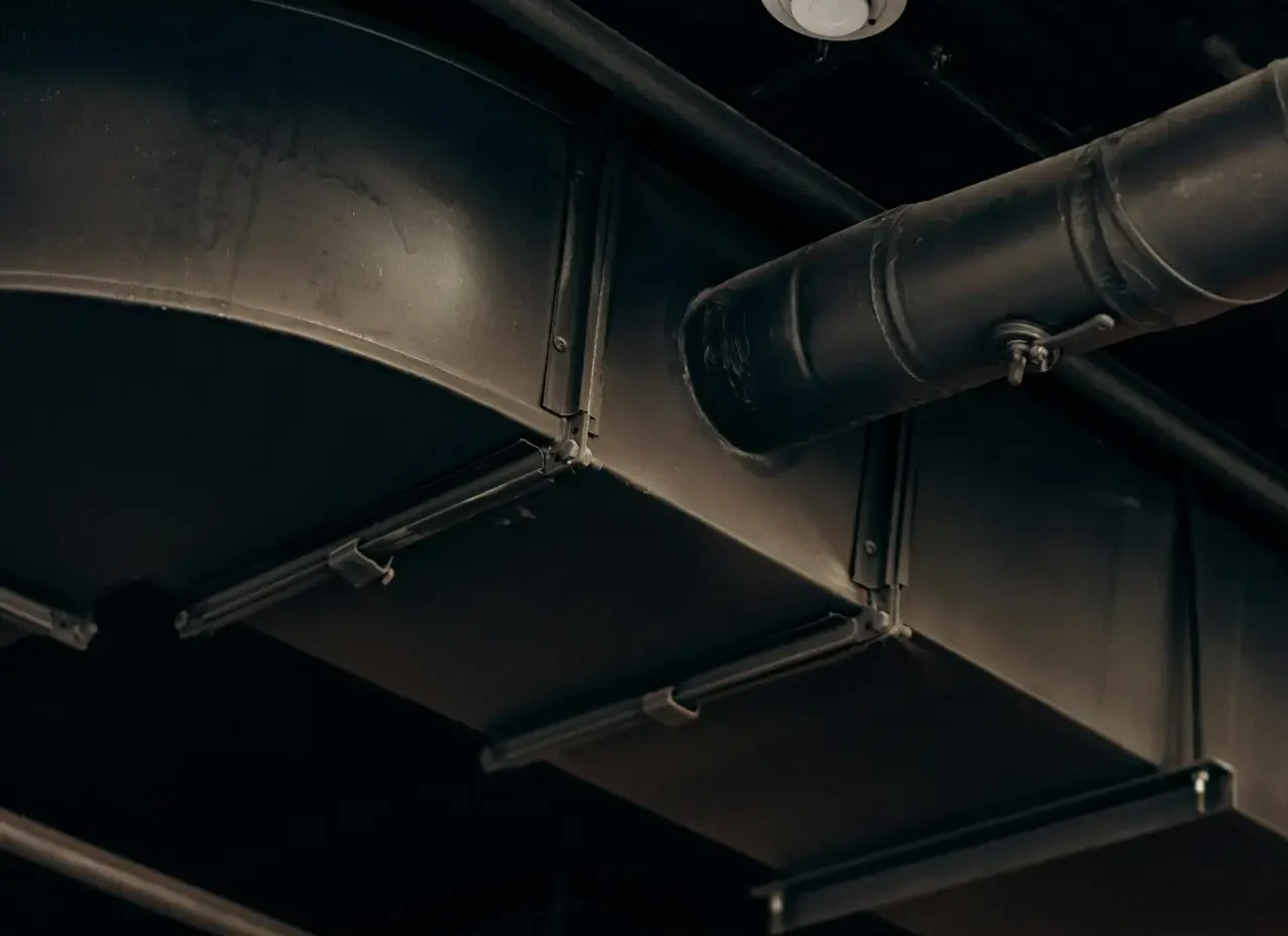 Detailed view of industrial air ducts on a ceiling, showcasing modern urban design.